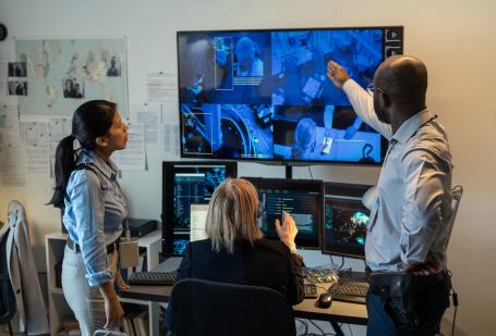 Three people looking at surveillance footage