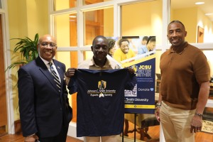 Dr. Eugene Okyere-Kwakye holds up a 皇冠体育 E Sports and Gaming Shirt with Dean Ogbuehi and Dr. Cash