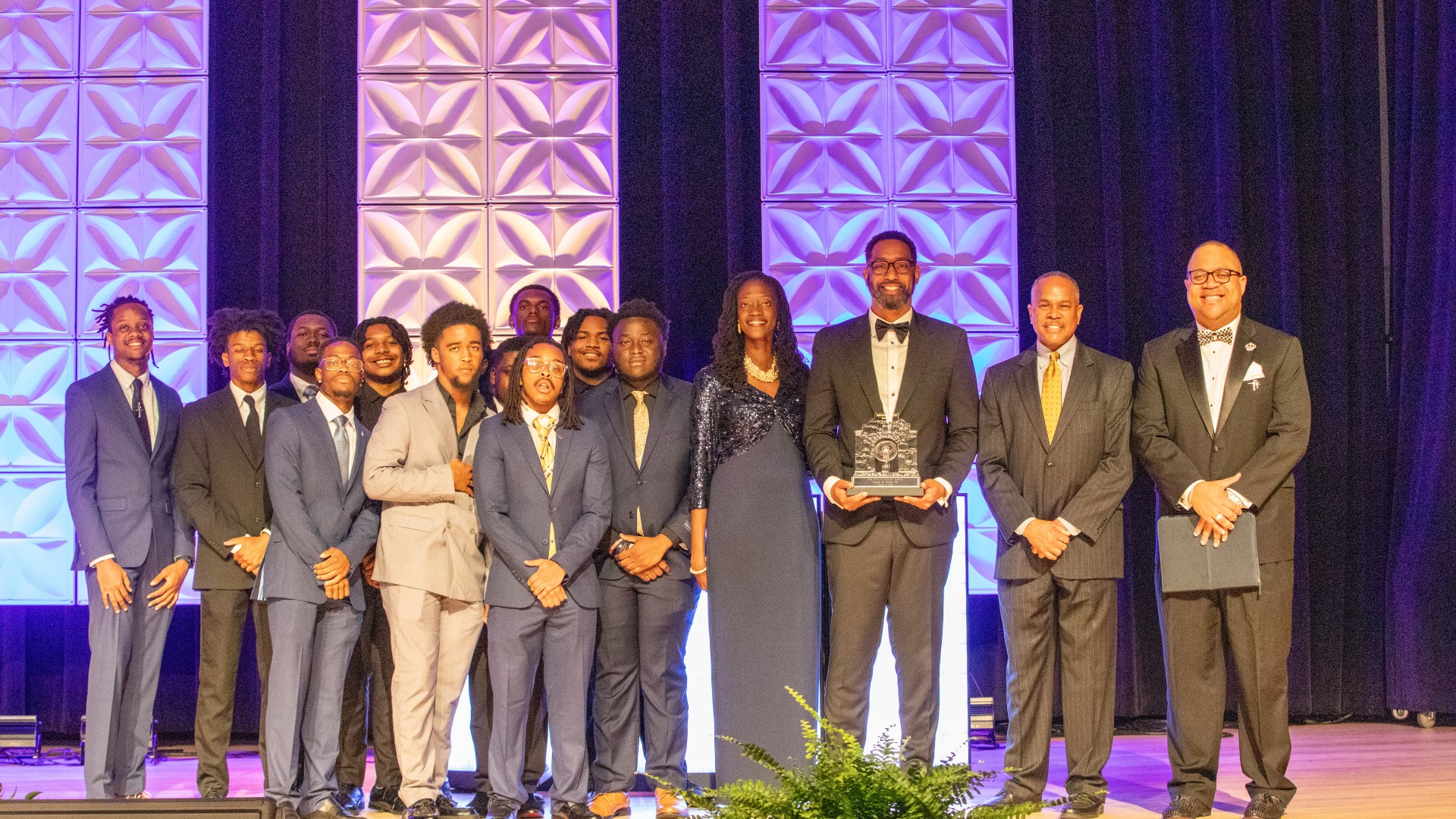 Lex Bibbs Posing with the AOT Gala Award and the Becoming Kings group